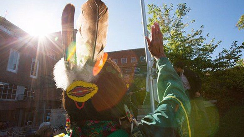 individual in front of UO building in decorated hat with feathers